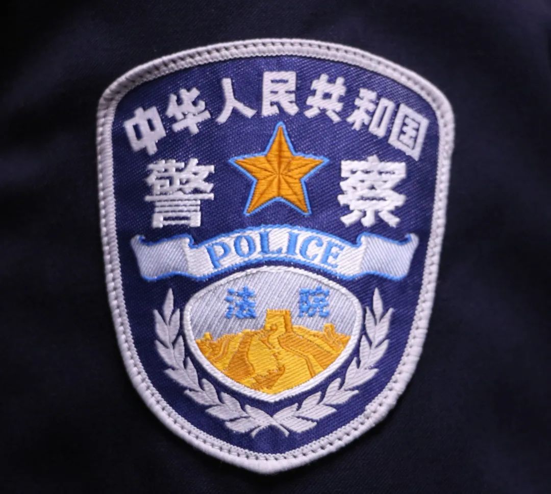 法警佩带人民警察警衔肩章,胸标字样为"法院",臂章长城上方字样为"