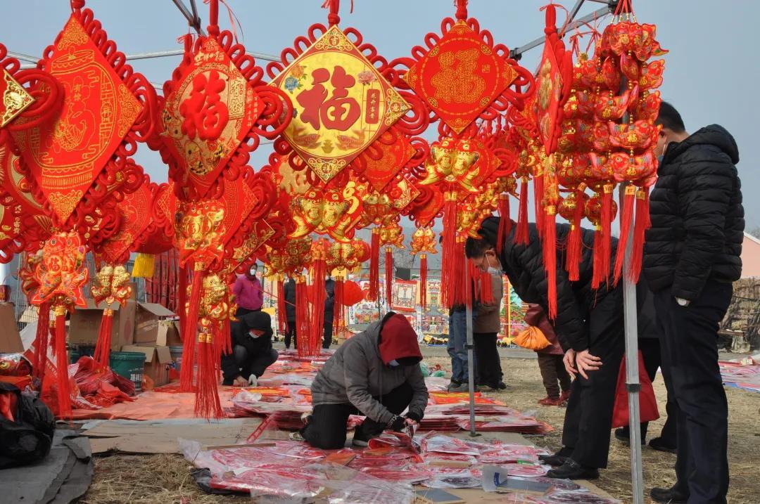 临近春节,各种福字和春联摊位,花卉摊等传统年货,烘托出了浓浓的年味