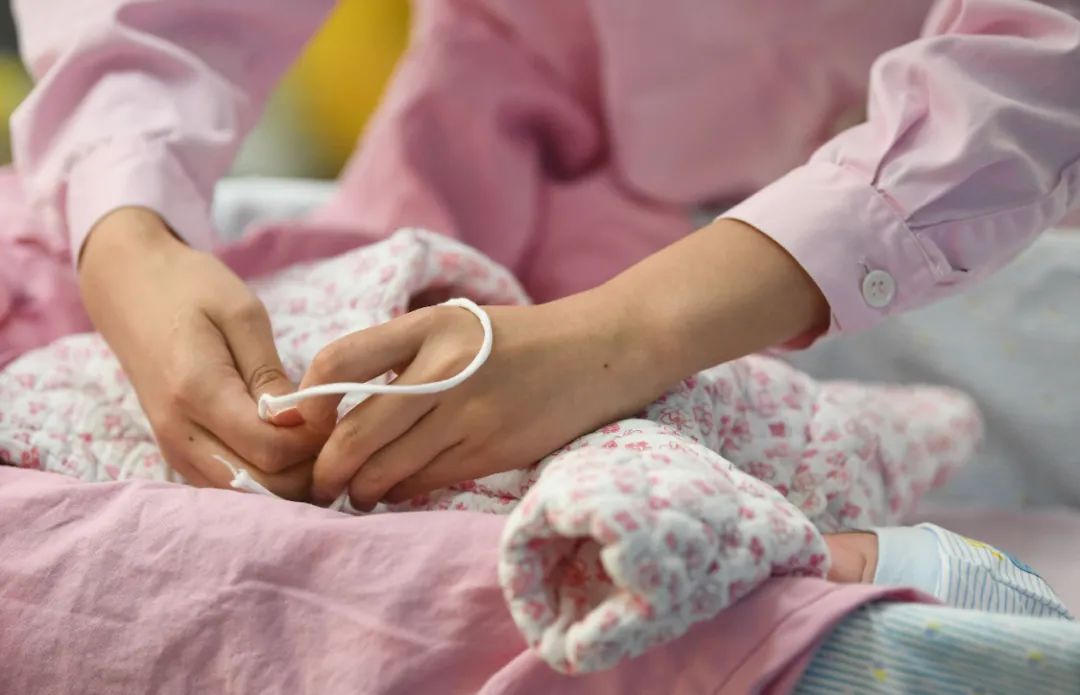 一名助产士在为刚出生的婴儿穿衣服 邓华 摄