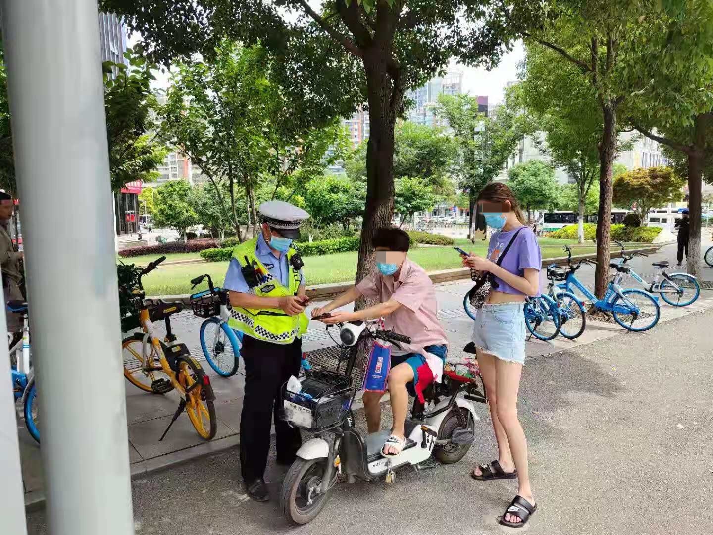 武汉洪山区交警严查电动车违规载人载货除隐患