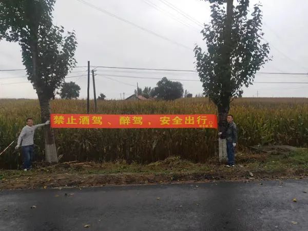 路段悬挂"保秋收,保安全"预防道路交通事故宣传横幅,通过加大宣传力度