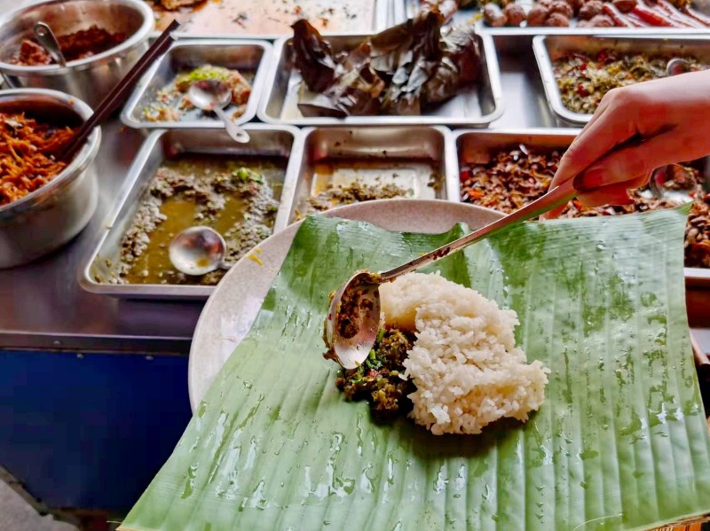 将傣族美食集合荤素搭配,加上食材染出的彩色糯米饭和水果,摆出各种