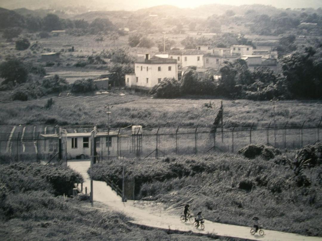 1978年罗芳村过境耕作口,铁丝网对面村子为香港新界绞寮村(何煌友摄)