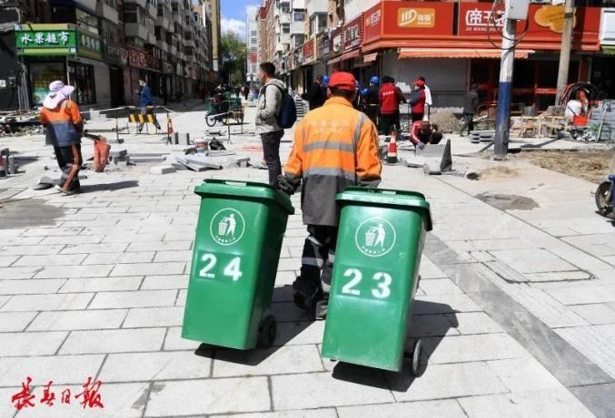 垃圾桶等辅助设施 正在安装和摆放 …… 绿色的垃圾桶 在路中央整齐地