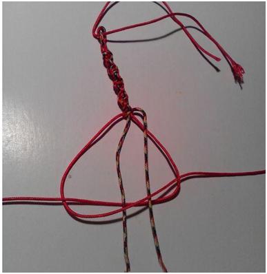 适量长度后挑两根红色绳继续编转运结绕另外两根五彩线,五彩线做芯线.