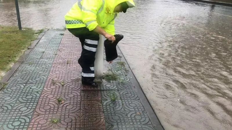 忙碌了几小时的交警队员,终于可以歇一下脚,倒一倒雨靴中的积水.