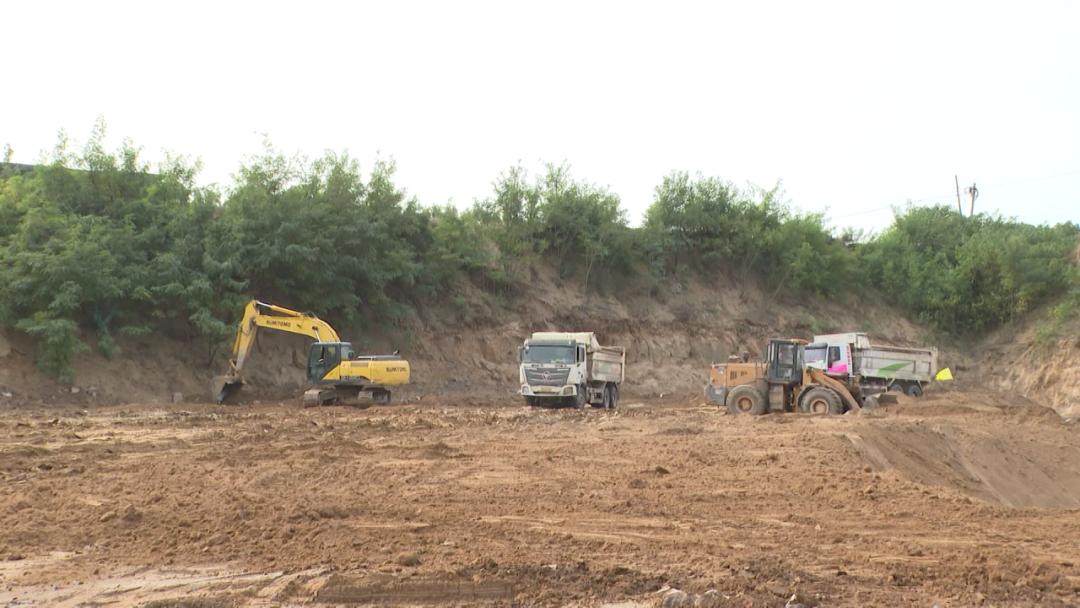 俯瞰新城大街湿地工程建设现场,运输车辆来回作业运送土方,挖掘机有的