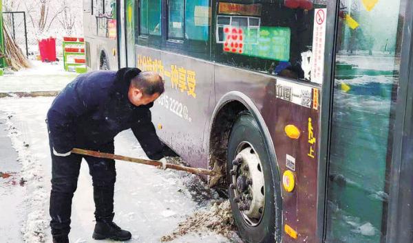 19日,公交集团东盛公司281路车队工作人员清理车辆上的积雪,确保乘客