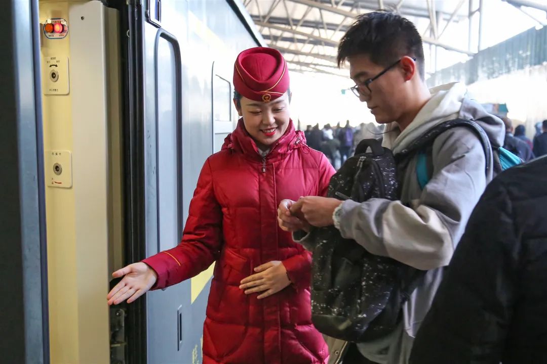 羽绒服和帽子搭配在一起守候在车厢门口等待旅客乘车列车员早已换上