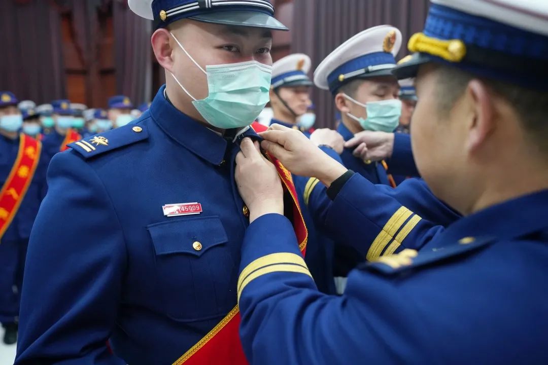 佩戴大红花肩披绶带画上一个圆满的句号为消防生涯向中国消防救援旗