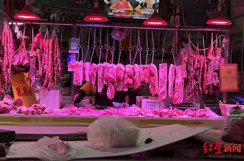 在一家菜市场内,被红色光线照亮的肉摊