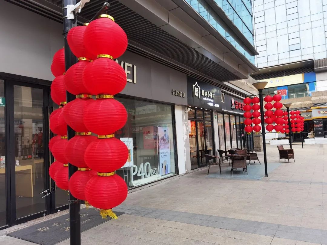 商家不仅用喜庆的春节元素布置店面,还在商圈广场摆