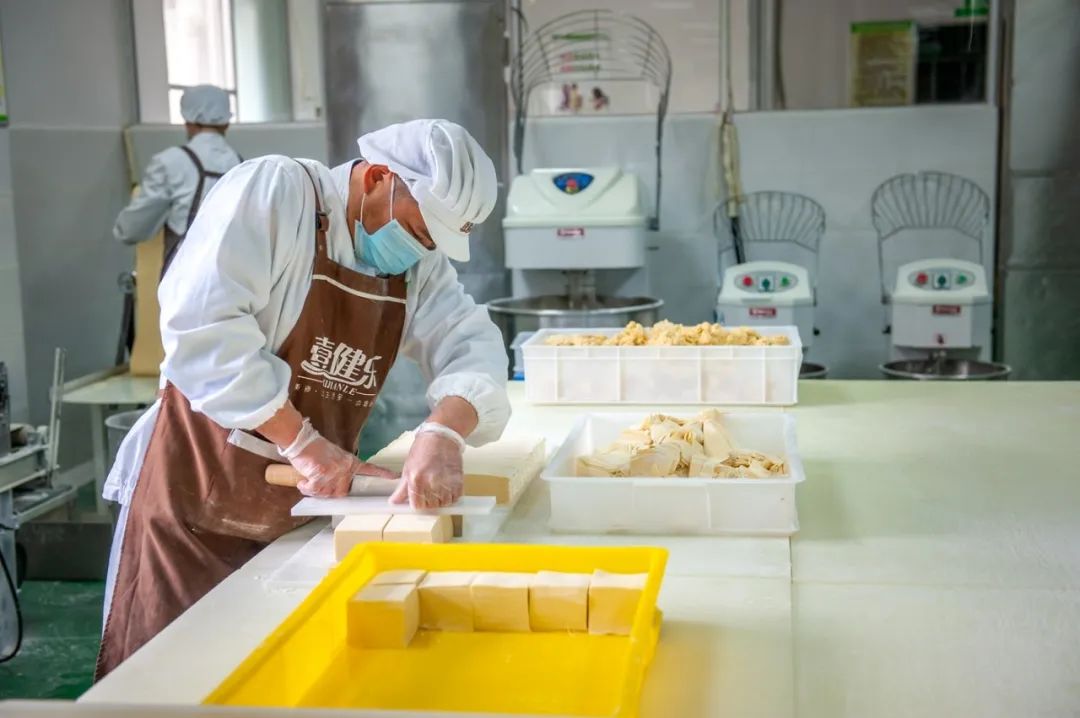 第一步和面:师傅用竹升打面.