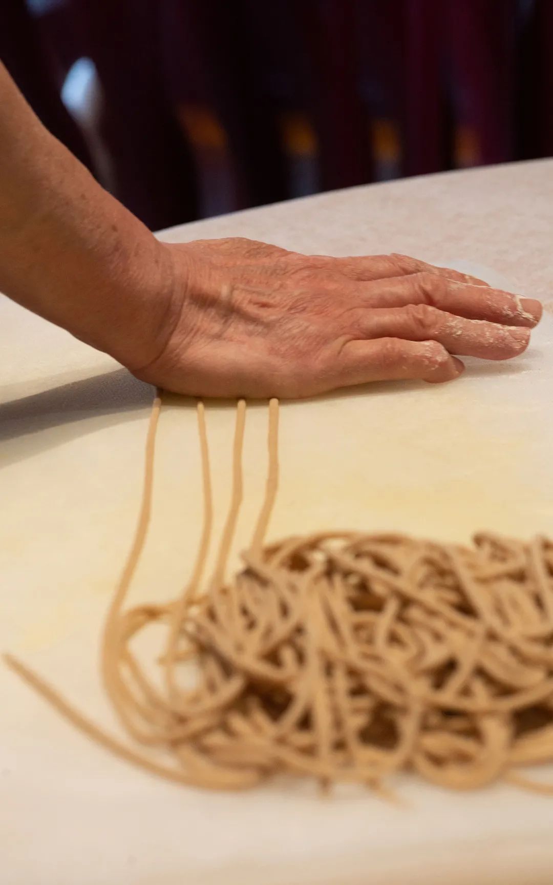 用手将莜面团在案板上搓成细细的面条,称之为"莜面绳绳".