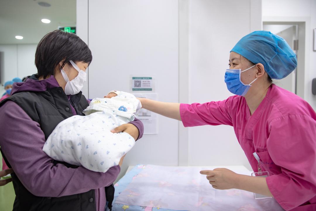 nicu护士为瑜儿穿上家人带来的新衣,把孩子交到母亲怀中.