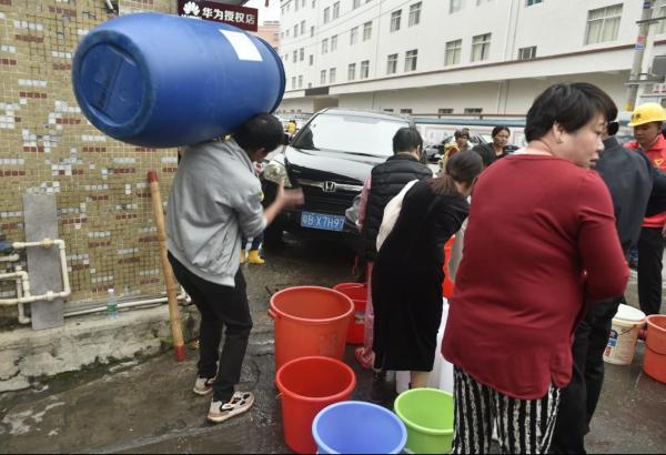 (居民带着各类容器排队取水)