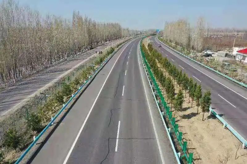 4月26日,在清伊高速伊宁市英也尔镇片区劳动现场,彩旗飘扬,车辆穿梭