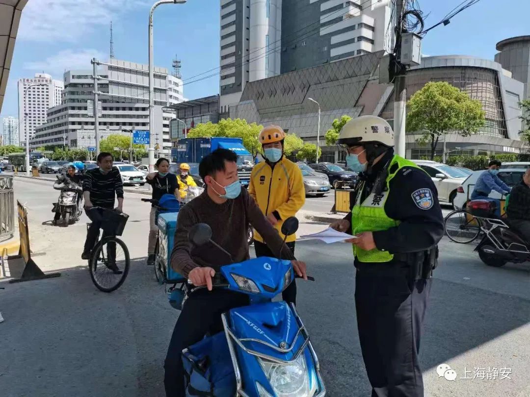 一位外賣小哥騎著電動車駛來,見到小哥未戴頭盔,交警上前提醒