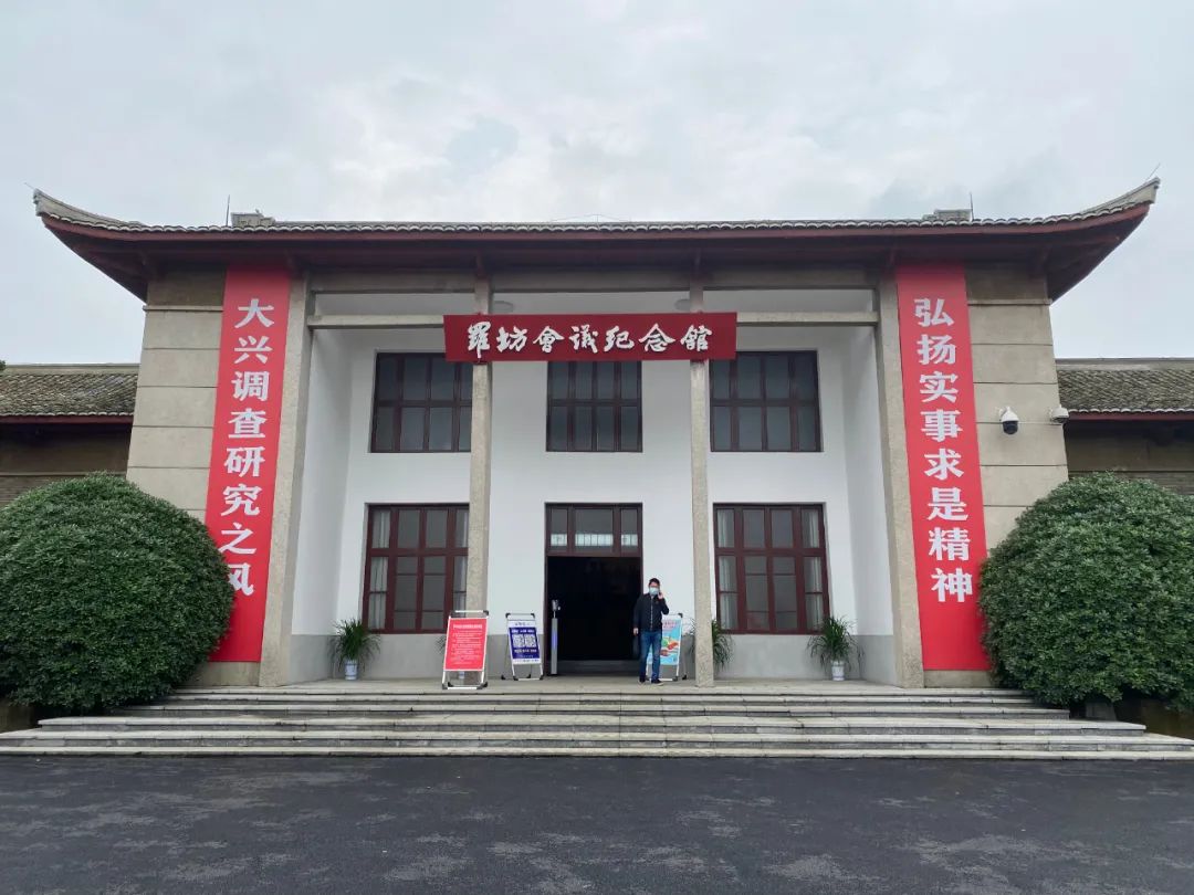 走进罗坊,五星红旗迎风飘扬,"传承红色基因,弘扬革命精神"等标语醒目