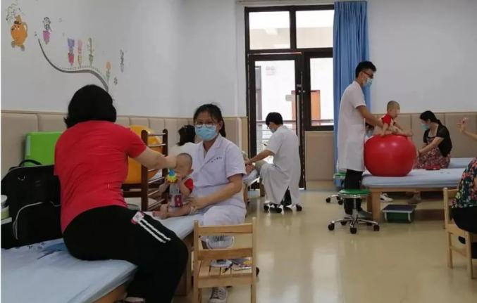 4月27日,谢女士和丈夫抱着小宇为刘自强等医护人员送上锦旗,眼眶里