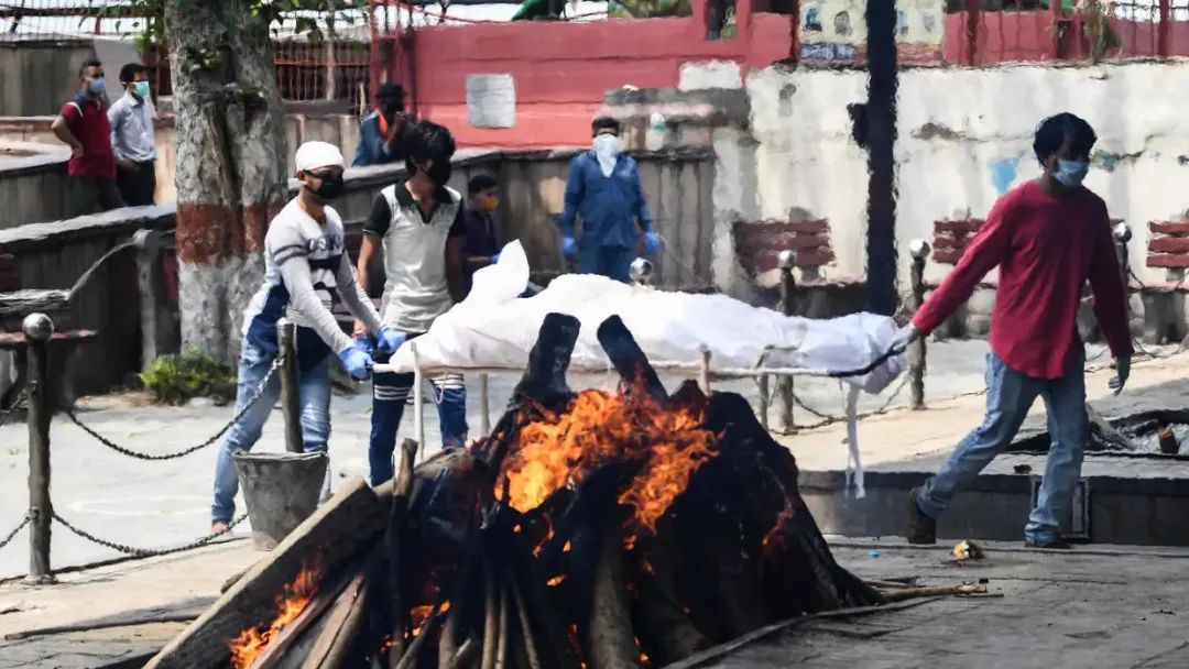 印度德里火葬场超载,新冠死者被露天架起柴火焚化