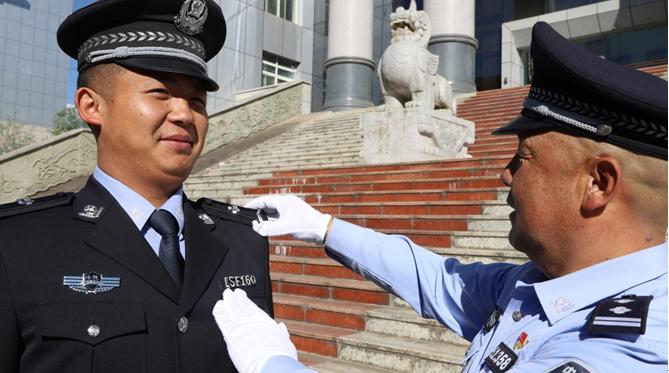 頒授儀式上,院黨組成員,司法警察大隊隊長沈躍為輔警頒授警銜,警號並