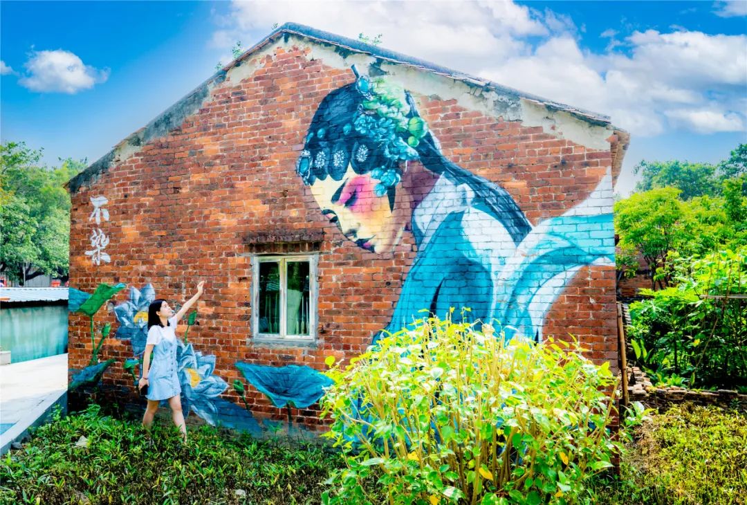 红砖墙上,粤剧花旦在低头吟唱,格外显眼.摄/穿行者