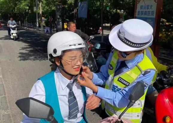 我为群众办实事中卫交警手把手为骑行者戴好安全头盔