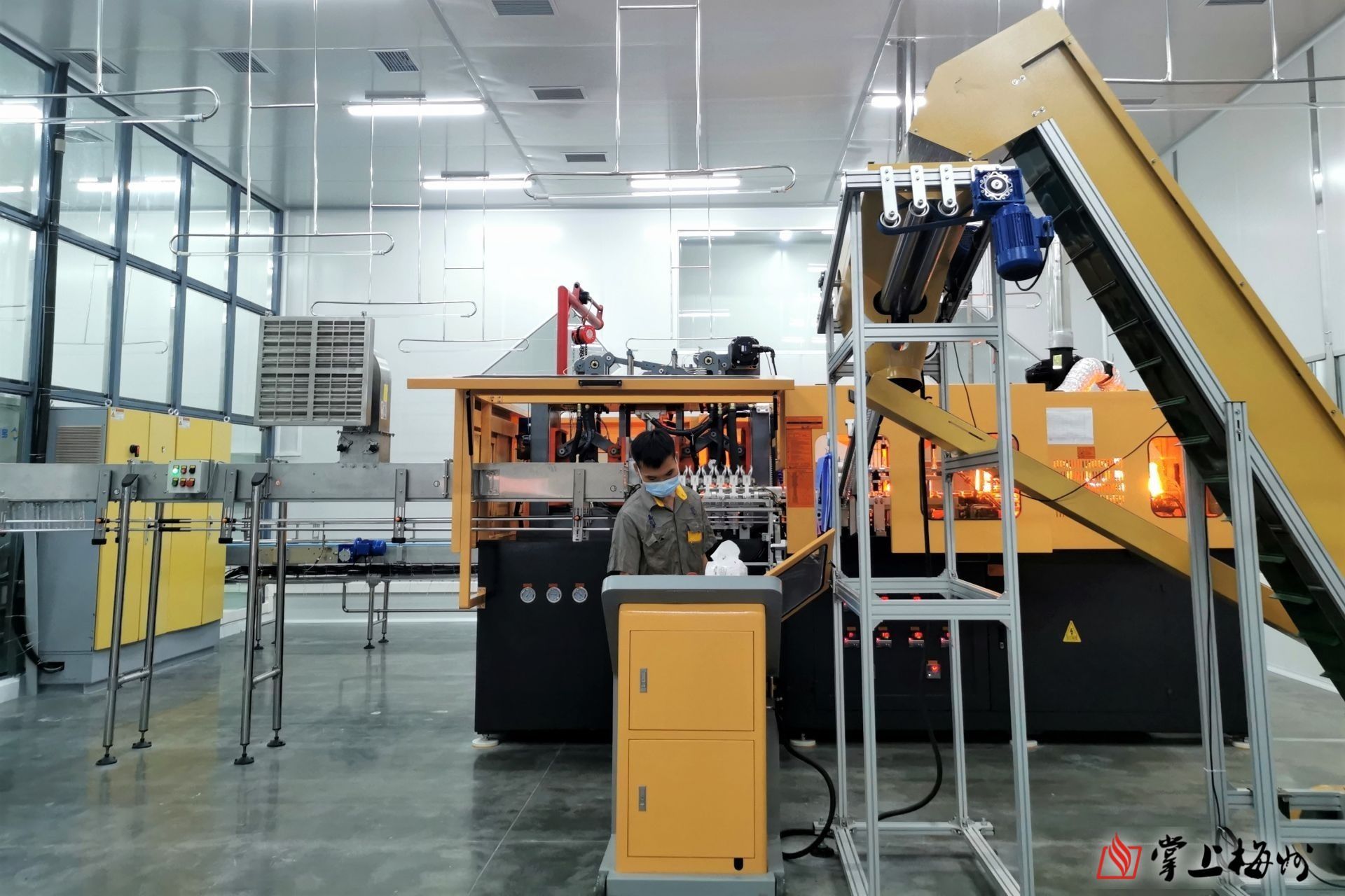 梅州市方印泉矿泉水有限公司工厂内的全自动吹瓶机. (江婵 摄)