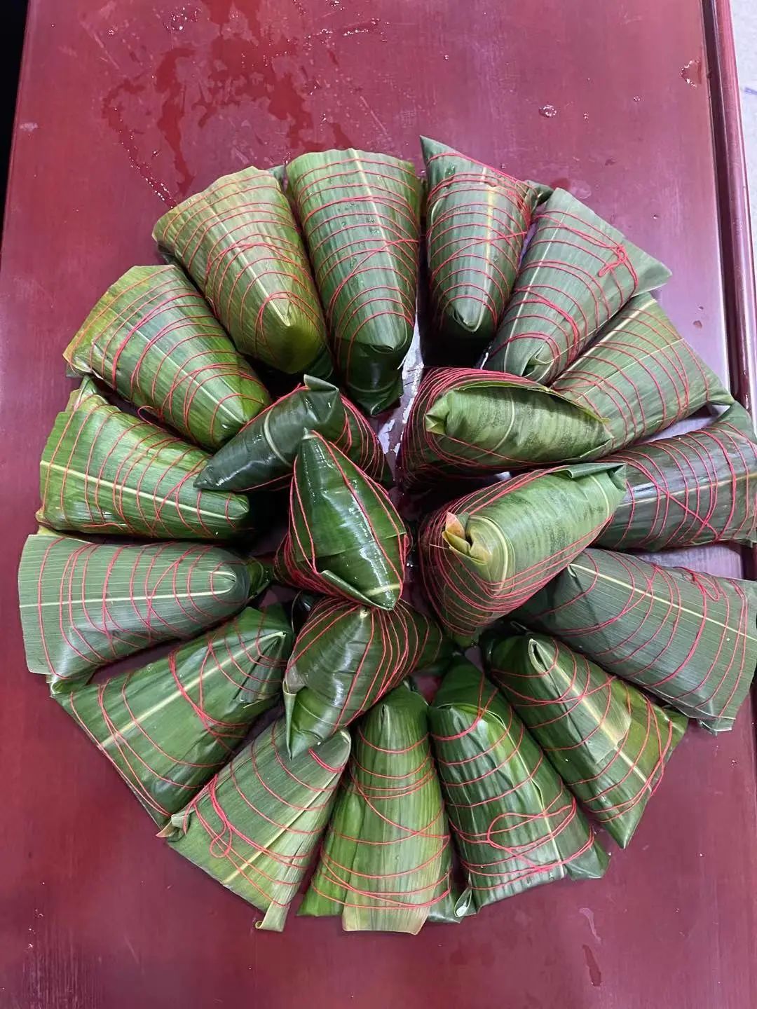 兰溪市游埠镇洋港村在文化礼堂举行端午节包粽子活动,志愿者们双手