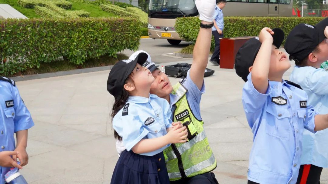 接触这些神秘威武的"武器"后,个个兴奋不已,好奇的上前围着警察"蜀黍"