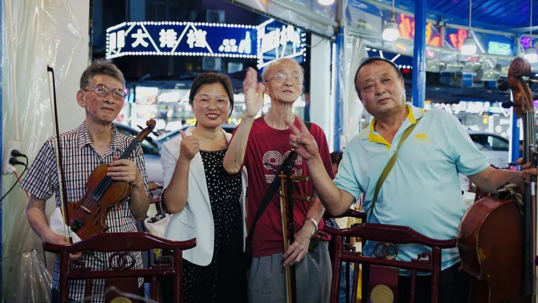 河南遊客孫玉鳳打卡吉慶街,和街頭藝人合影.