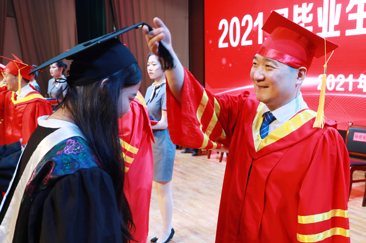 副校长缪峰为获得学士学位的毕业生代表拨穗授位