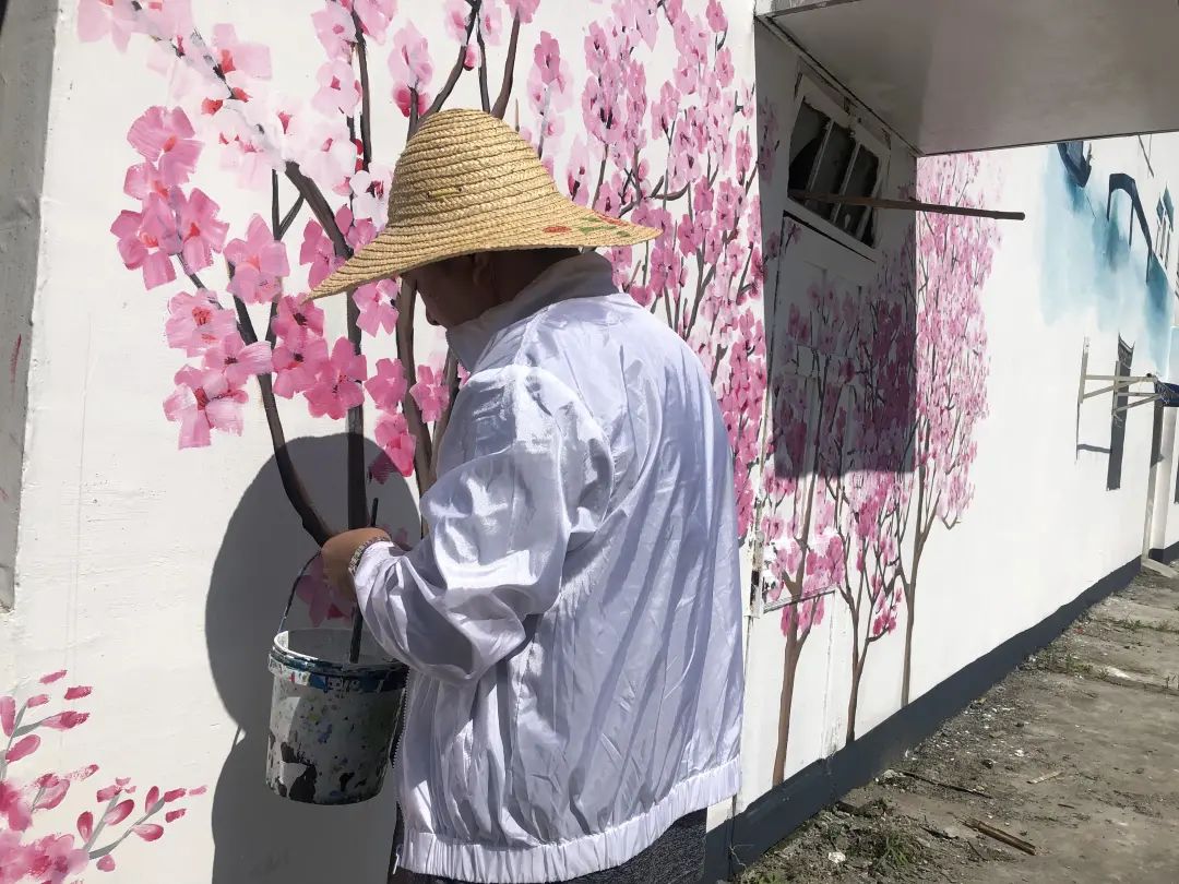 粉色桃花跃然墙上!路边白墙变彩绘墙