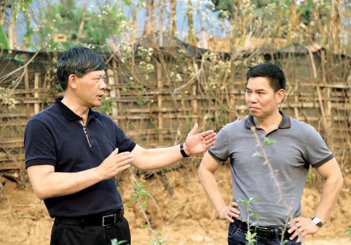 杨中兴(左)在勐朗镇大平掌村调研花椒产业