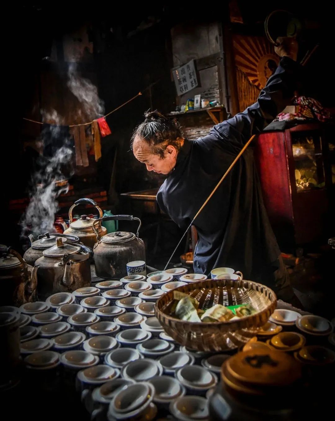 老虎灶是一间茶铺的"重器,一把铜茶壶提在幺师的手上,就茶铺堂子游动