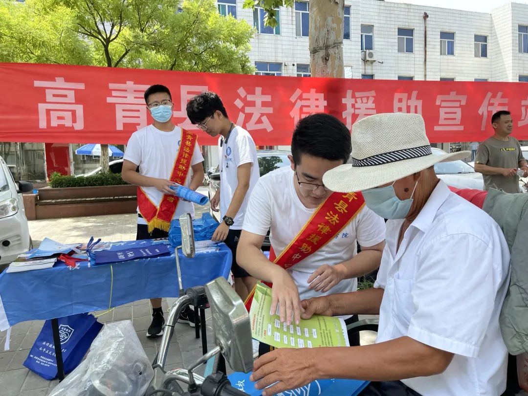 援助志願服務隊的工作人員身披紅色志願者工作綬帶,現場懸掛宣傳標語