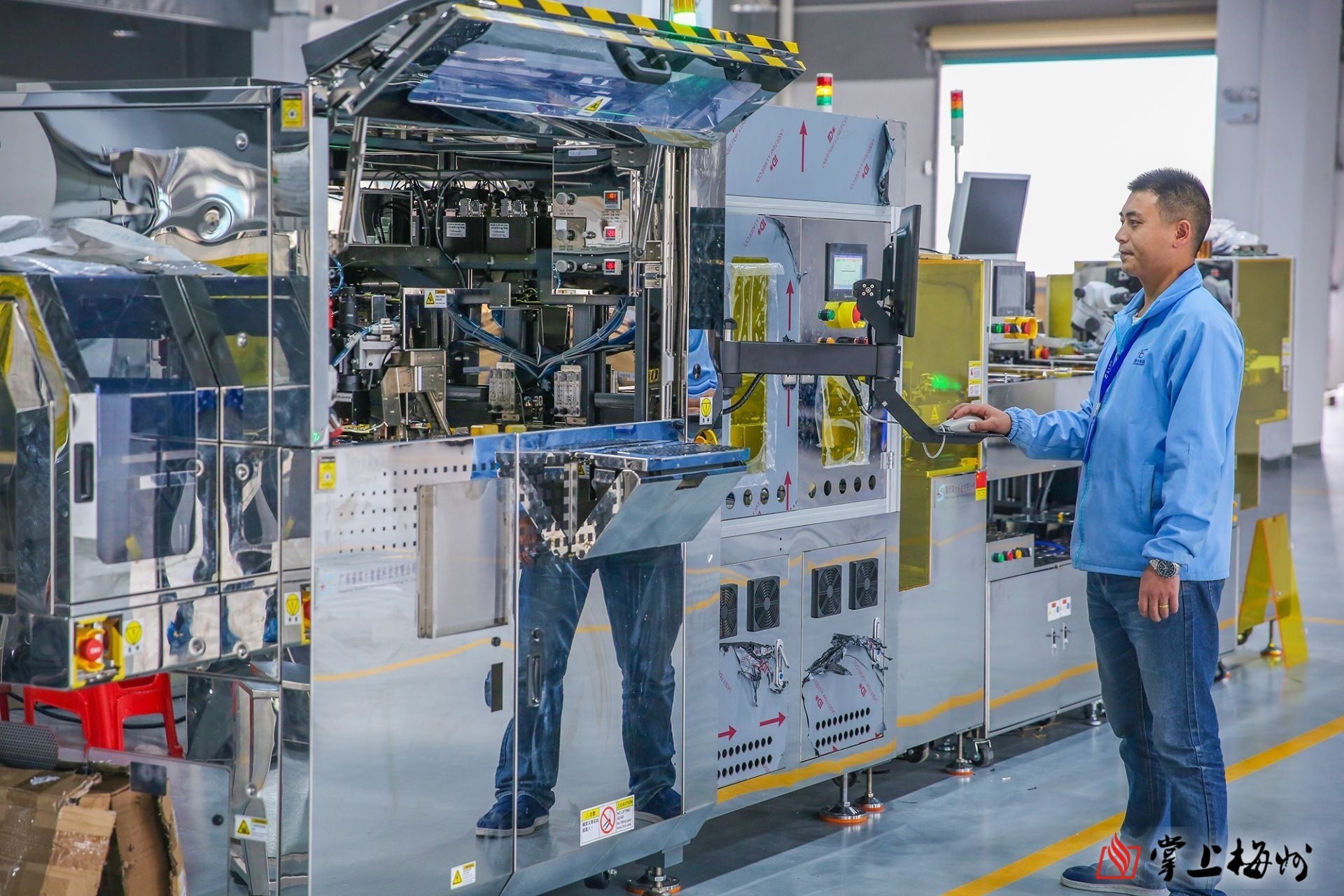 在双十智能科技有限公司车间,技术工人正在调试机器设备.