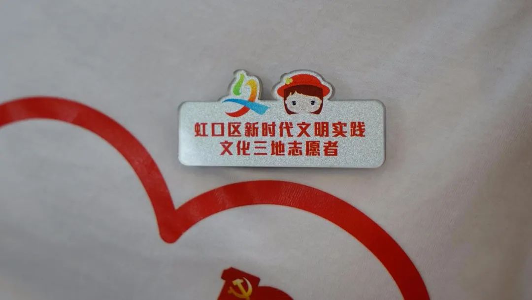 举着"文化三地"牌子的虹口区新时代文明实践志愿者胸牌一群佩戴近日