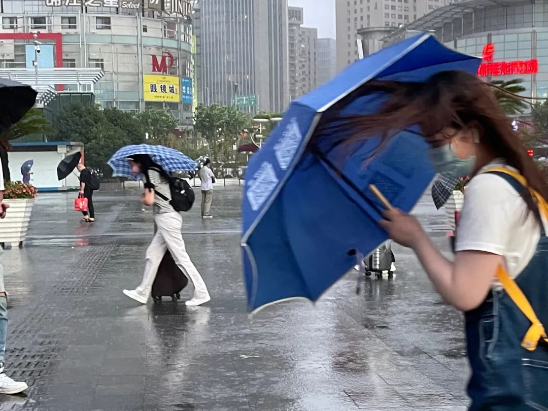 行人顶着台风艰难行进,不忘刷手机 图源:东方ic