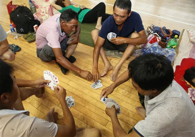 工人们聚在一起打牌娱乐,消磨时光.