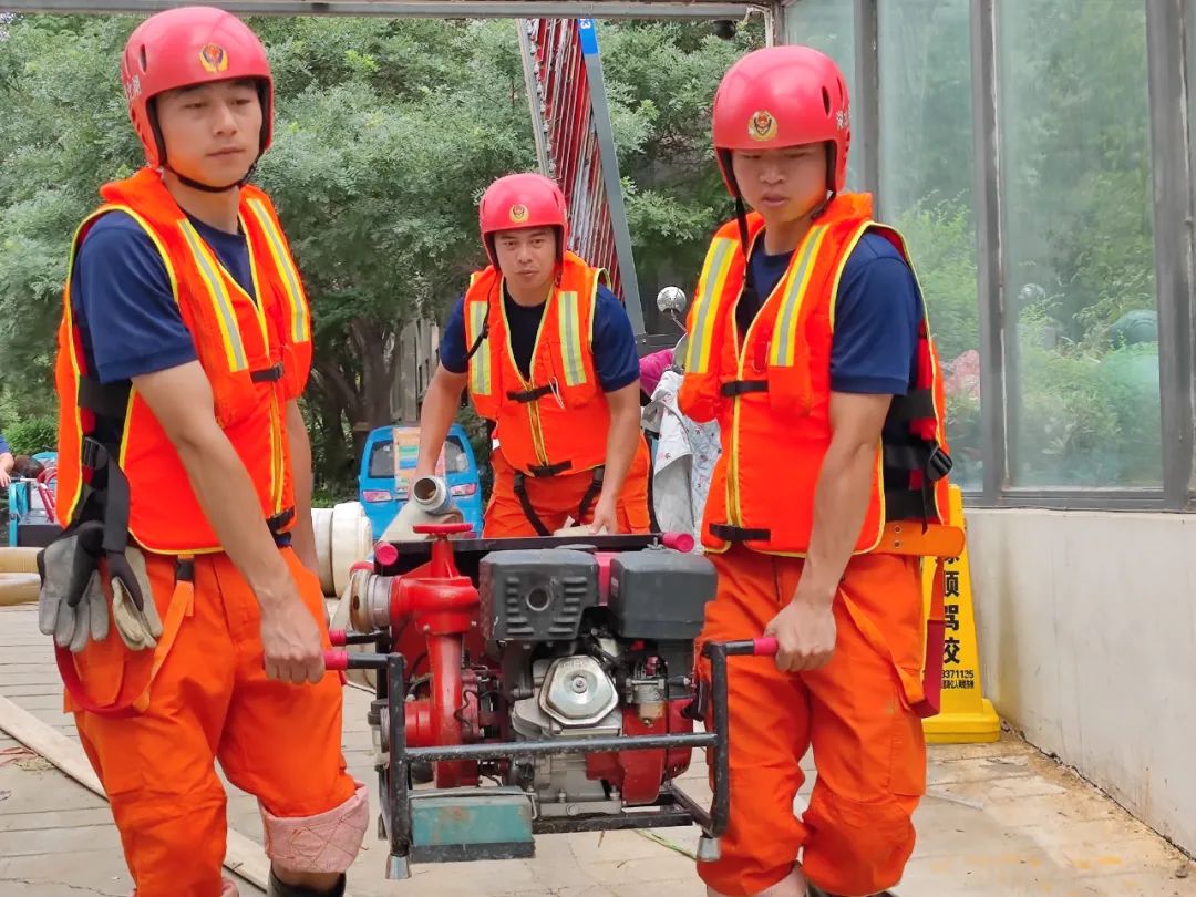 消防人员正在手抬机动泵