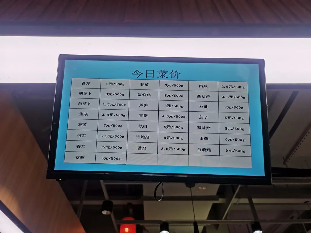 悬挂着电子显示屏,上面滚动播放着经营者执证信息,在售商品菜价等信息