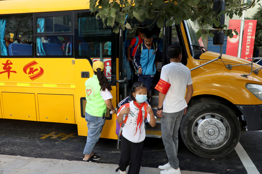 校车抵达华侨中小学后学生陆续下车
