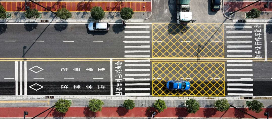 道路 专门施划和设置了黄色网状线 限速标志,安全提示牌等交通标线和