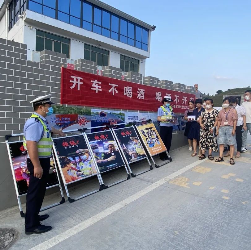 民警在村庄主干道,人流密集点悬挂横幅,摆放展板,粘贴海报,发放宣传单