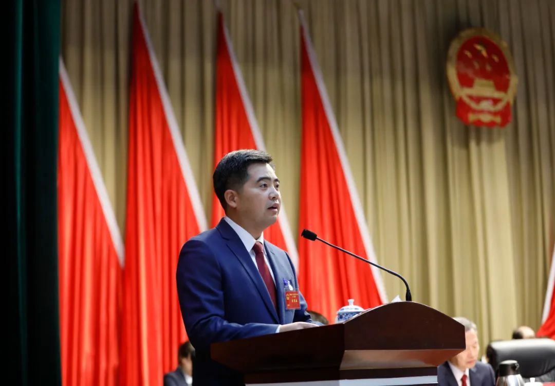 在热烈的掌声中,区委副书记,区长胡俊峰代表人民政府向大会作政府工作