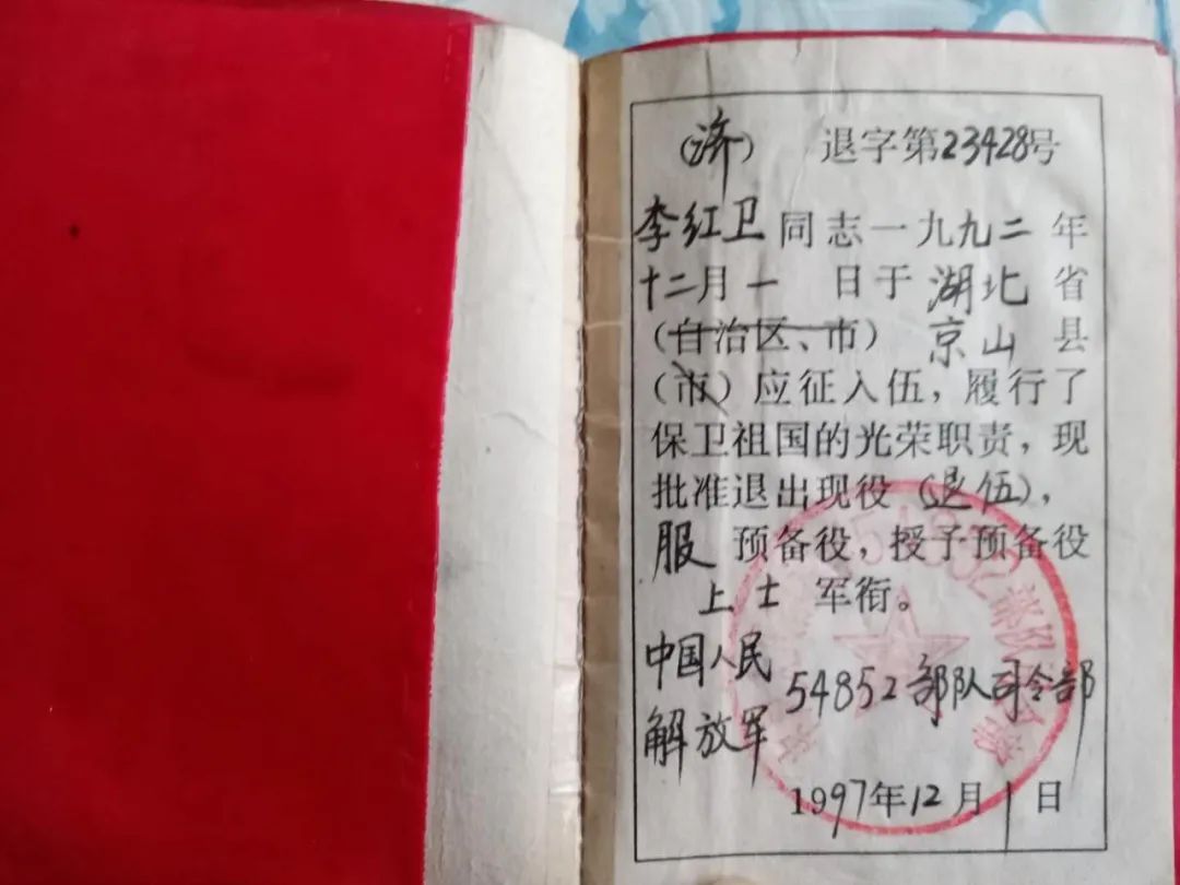 李紅衛的退伍證及立功受獎證書,獎章為強國強軍夢貢獻自己的力量受