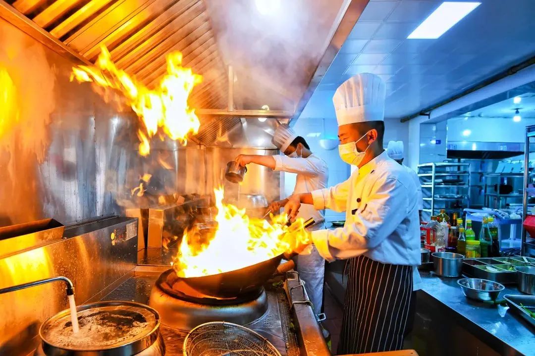 热油猛火,颠勺翻炒各样食材在大厨们勺与锅的碰撞中成为一盘盘秀色可