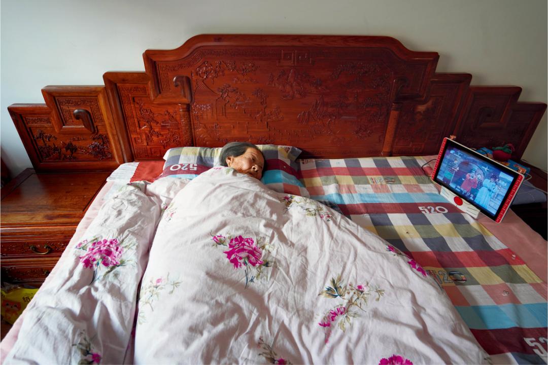 老人是个戏迷,因病卧床,家人特意给她买了一台看戏机.